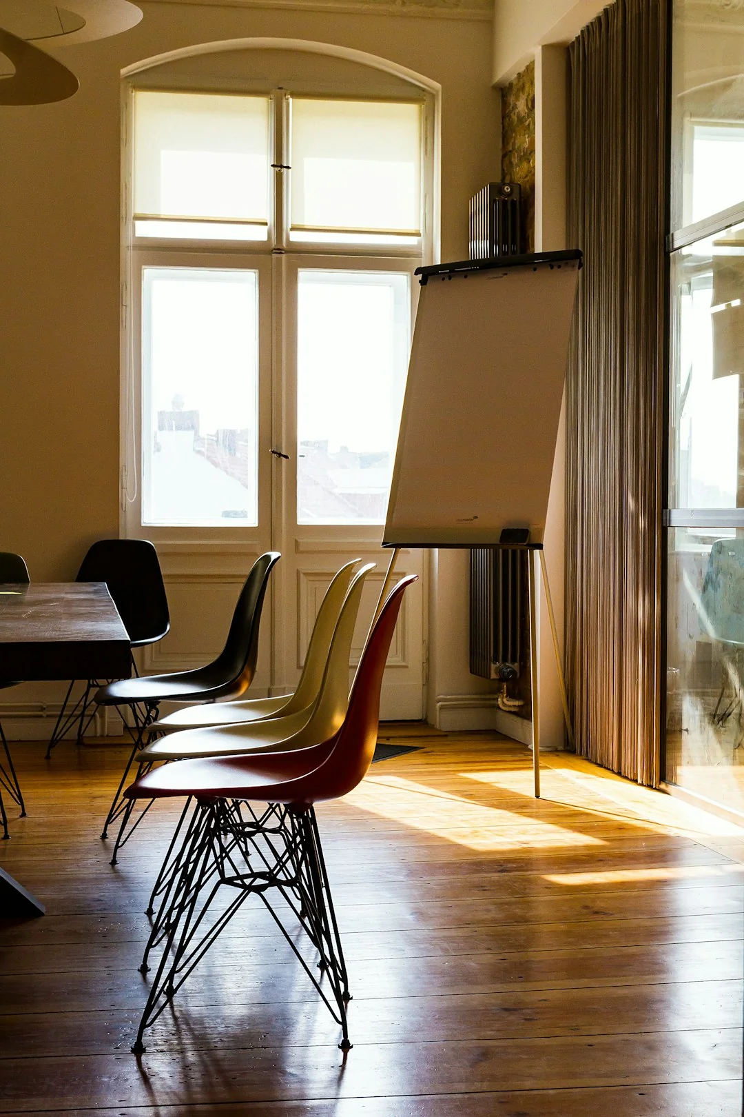 Minimalist yoga studio with aerial hammocks and blank laptop screen on a stool, ideal for diverse wellness themes.